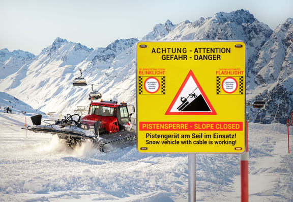Pistenraupe im Einsatz bei Schnee und das neue Alform - Pisten Guard Warnschild