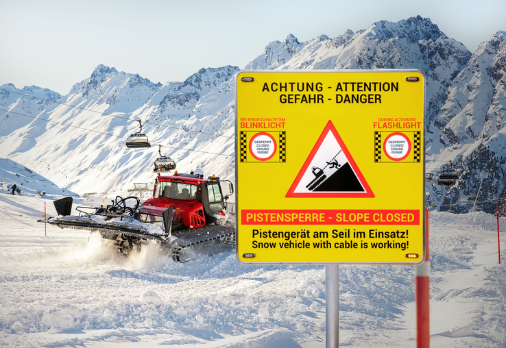 Pistenraupe im Einsatz bei Schnee und das neue Alform - Pisten Guard Warnschild