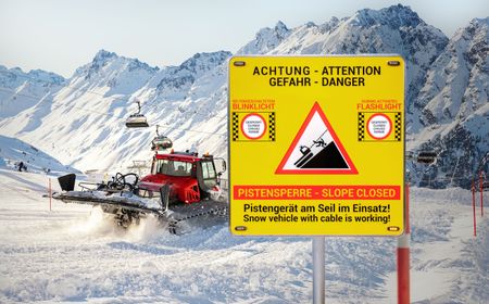 Pistenraupe im Einsatz bei Schnee und das neue Alform - Pisten Guard Warnschild