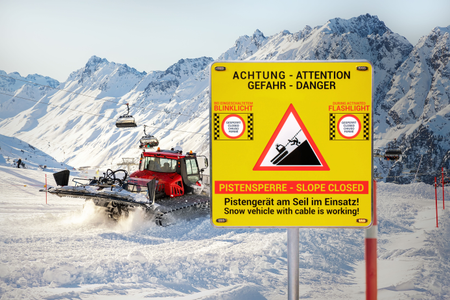 Pistenraupe im Einsatz bei Schnee und das neue Alform - Pisten Guard Warnschild